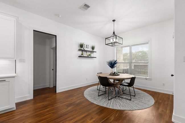 Dining area featuring an inviting chandelier, baseboards, dark wood finished floors, and visible vents | Image 9