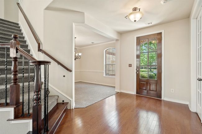 The inviting entryway includes wood floors, lots of natural light, with views into the family room, dining, and office. | Image 7
