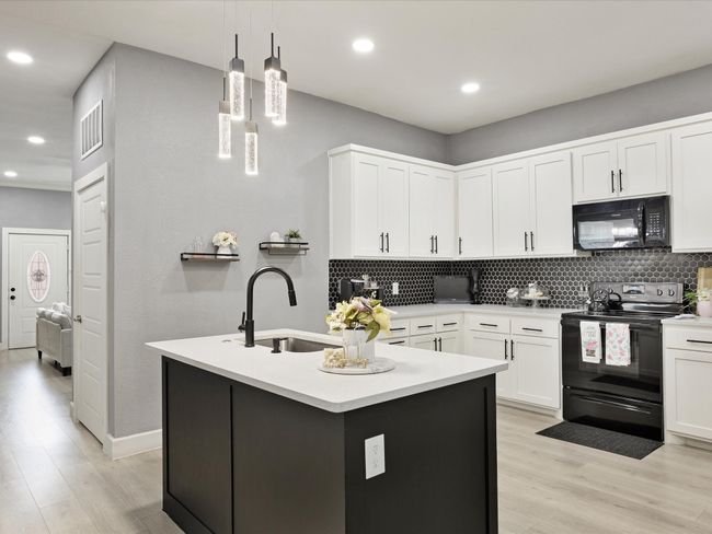 Kitchen featuring black appliances, a sink, decorative backsplash, light wood-style flooring, and recessed lighting | Image 19