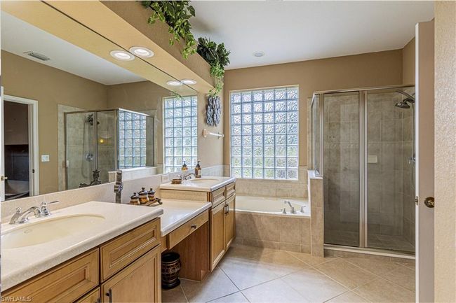 Full bath featuring a sink, a garden tub, a shower stall, and tile patterned flooring | Image 19