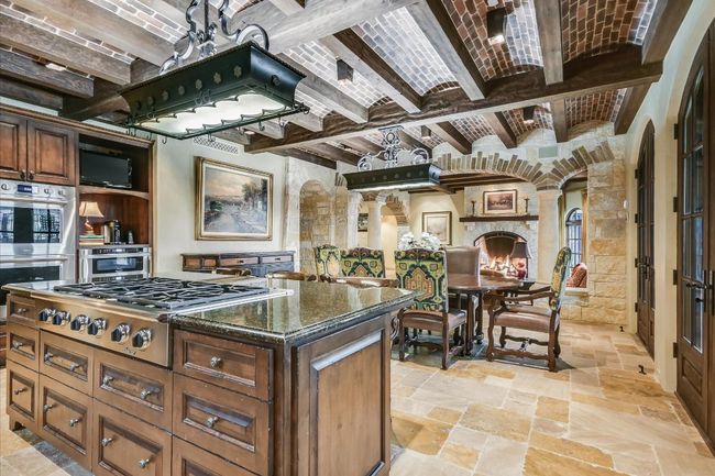 Kitchen featuring brick ceiling, arched walkways, stone tile flooring, and stainless steel appliances | Image 14
