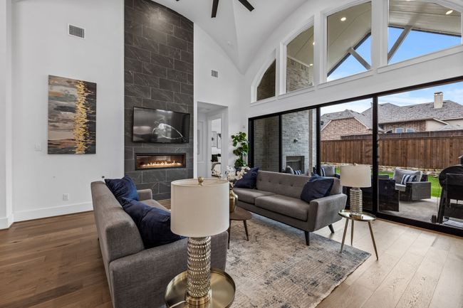 Living room with a fireplace, hardwood / wood-style flooring, high vaulted ceiling, and ceiling fan | Image 8