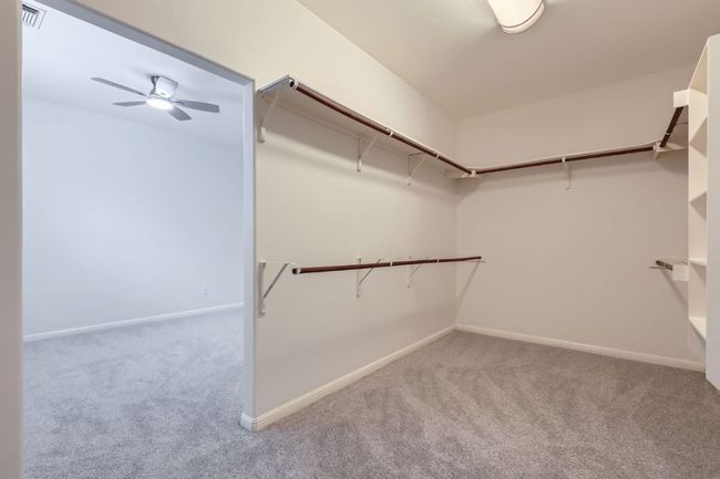 View of primary closet and bonus room with ceiling fan | Image 21