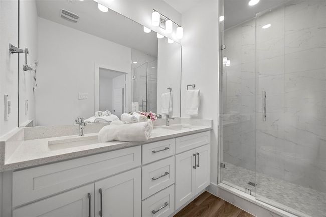 Full bathroom with double vanity, a marble finish shower, wood finished floors, and recessed lighting | Image 14