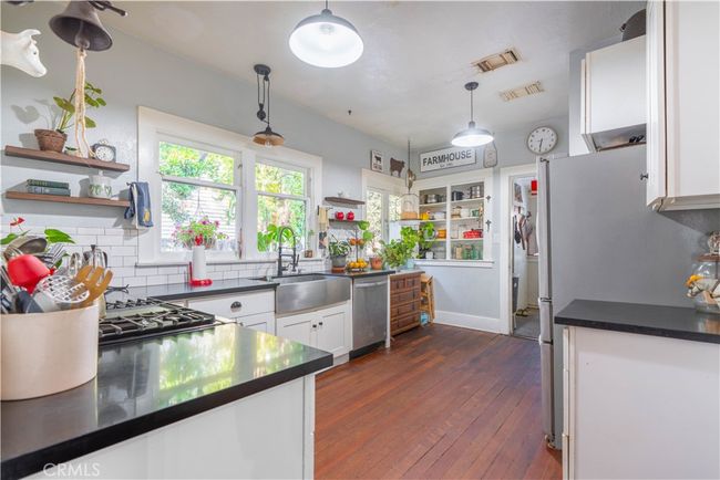Remodeled farmhouse-style kitchen with gas range, utility sink, and plenty of cabinet space. | Image 36
