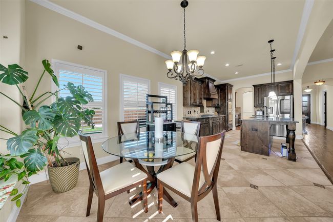 Dining space featuring arched walkways, ornamental molding, a chandelier, recessed lighting, and light tile patterned floors | Image 11