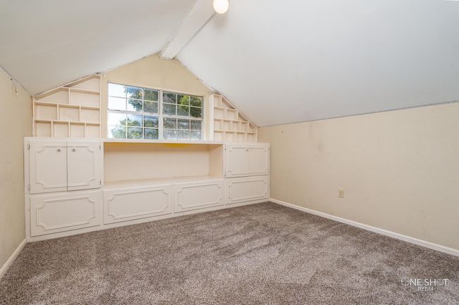 Additional living space featuring vaulted ceiling with beams, carpet, and built in features | Image 28