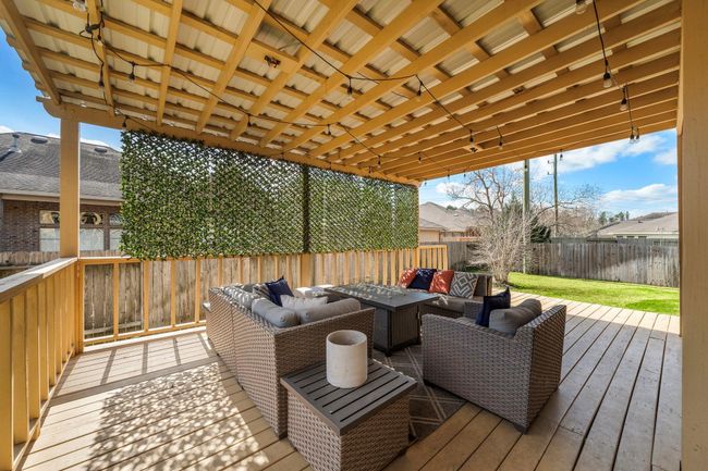 Overlooking the lush green space, the covered patio serves as an inviting extension of the home’s living areas. | Image 34