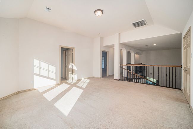 Carpeted spare room featuring vaulted ceiling and arched walkways | Image 20