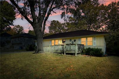 Single story home featuring a wooden deck and a lawn | Image 2