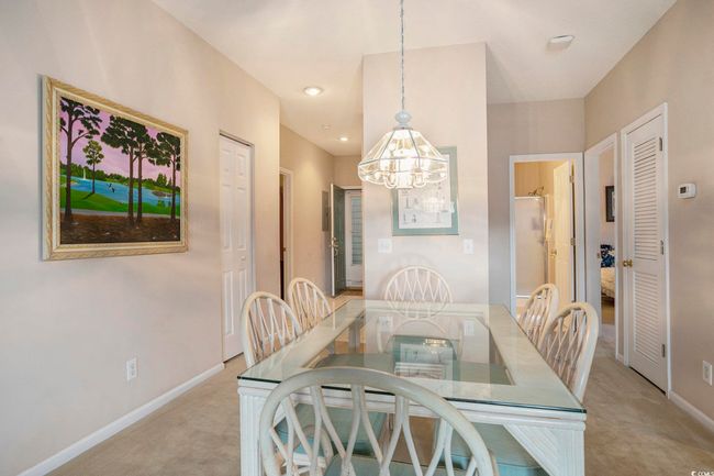 Dining area featuring light carpet, a chandelier, and baseboards | Image 4