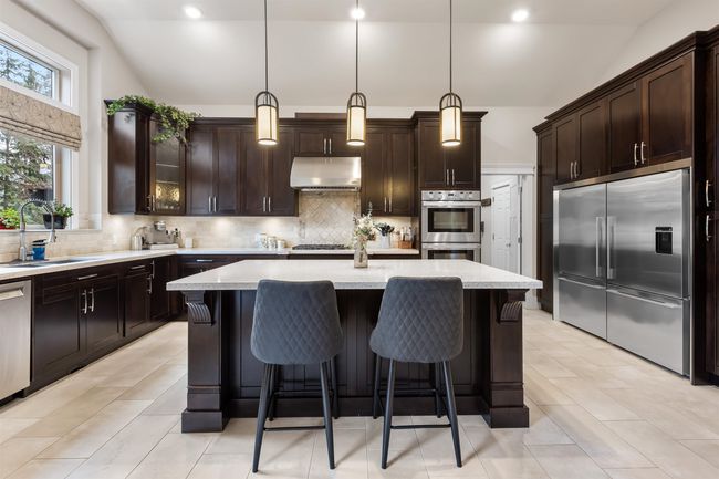 Kitchen featuring under cabinet range hood, appliances with stainless steel finishes, backsplash, and a sink | Image 11