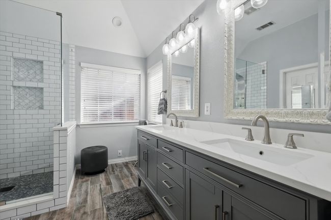 Full bathroom with a shower stall, lofted ceiling, wood finished floors, and double vanity | Image 16