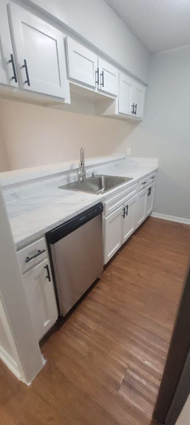 Kitchen featuring stainless steel dishwasher, white cabinetry, and dark wood-type flooring | Image 21