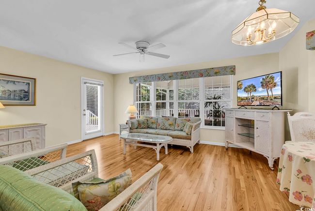 Living area with a chandelier, light wood-style flooring, and a ceiling fan | Image 21