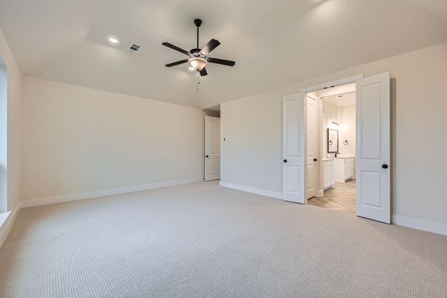 Unfurnished bedroom featuring light colored carpet, baseboards, vaulted ceiling, and visible vents | Image 16