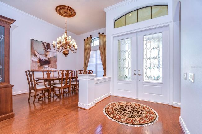 Step into elegance with this charming entryway and dining room, where the grand chandelier sets a tone of sophistication. | Image 4