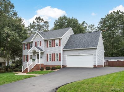 Colonial home with a front yard and a garage | Image 1