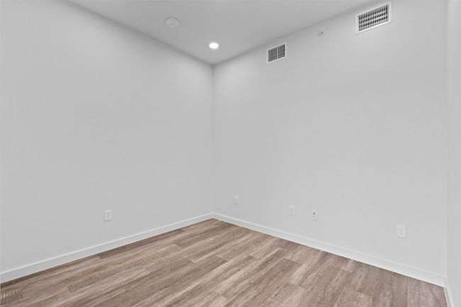 Empty room with wood finished floors, baseboards, and recessed lighting | Image 14