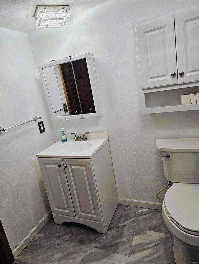Bathroom featuring baseboards, toilet, and vanity | Image 8