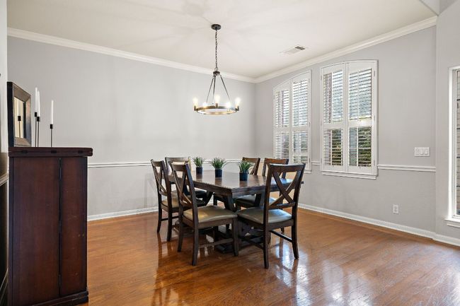 The dining room is beautiful with fresh paint and updated light fixture. Plantation shutters look out over the front yard. | Image 7