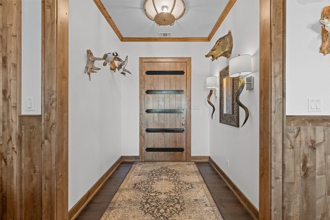 Doorway to outside featuring crown molding and dark wood finished floors | Image 6