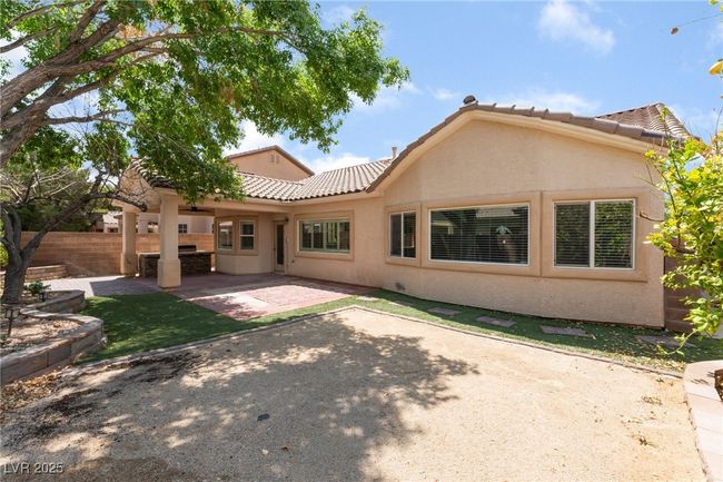 Rear view of house featuring stucco siding, a tile roof, and a patio area | Image 46