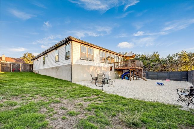 Rear view of property with a wooden deck, stairs, and a patio | Image 17