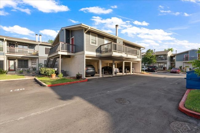 View of property with covered and uncovered parking, central AC, and a residential view | Image 10