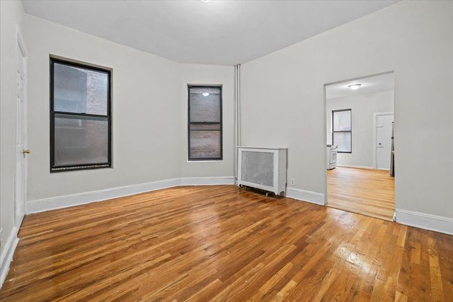 Unfurnished room with wood finished floors and heating unit | Image 10