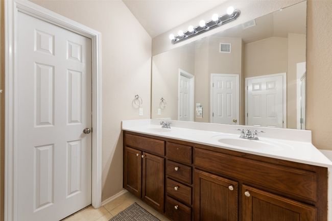 Full bathroom with double vanity, tile patterned floors, and lofted ceiling | Image 19