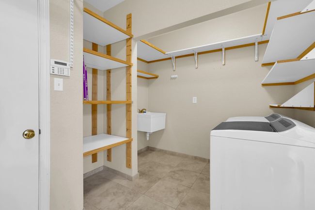 Laundry room with baseboards, washer and clothes dryer, laundry area, and light tile patterned floors | Image 37