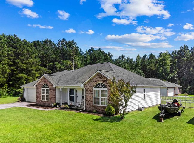 Ranch-style house with brick siding, concrete driveway, and a shingled roof | Image 18