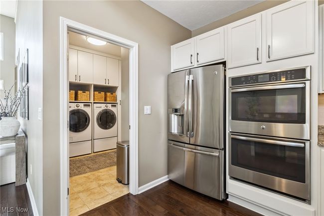 Refrigerator and double ovens and view of laundry room access | Image 16