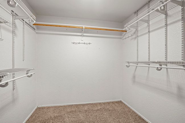 Primary Walk in closet featuring carpet | Image 18