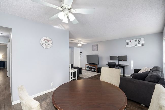 Dining room with dark wood-type flooring, ceiling fan | Image 11