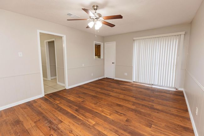 Unfurnished room with ceiling fan, wood-type flooring, and baseboards | Image 12