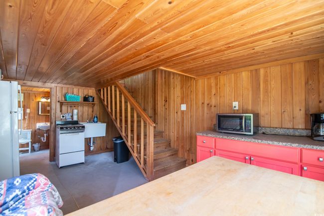 Kitchen featuring white appliances, wood ceiling, and wood walls | Image 6
