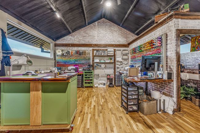 Office space featuring wooden ceiling, lofted ceiling, brick wall, wood finished floors, and track lighting | Image 4