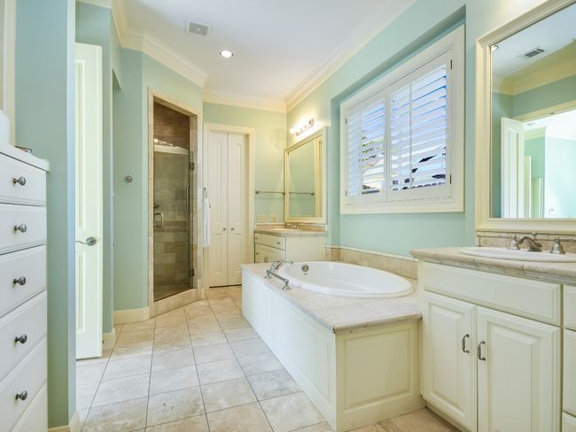 Bathroom with a stall shower, vanity, a garden tub, ornamental molding, and recessed lighting | Image 13