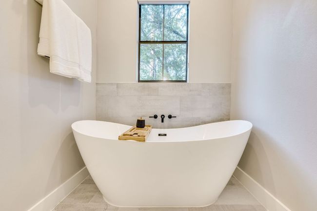The primary ensuite features this deep soaking tub, quartz countertops and dual vanities. | Image 24