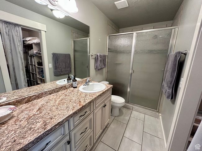 primary bath featuring vanity, a shower stall, a spacious closet, and toilet | Image 15