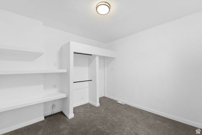 Spacious closet featuring dark carpet and visible vents | Image 17