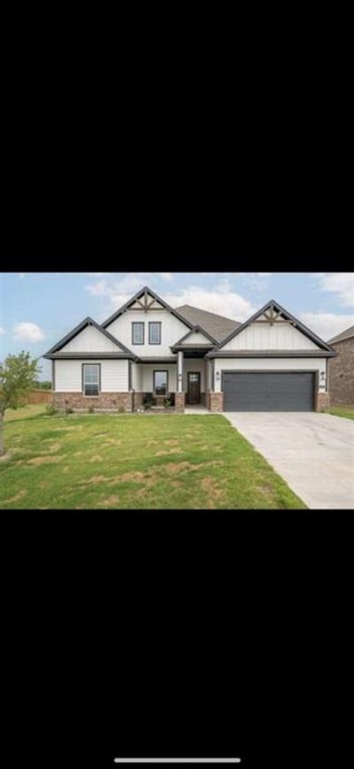 View of front of home featuring a garage and a front yard | Image 1