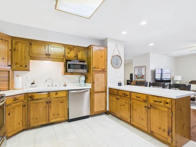 Kitchen with a sink, wood cabinetry, a peninsula, and stainless steel appliances | Image 40