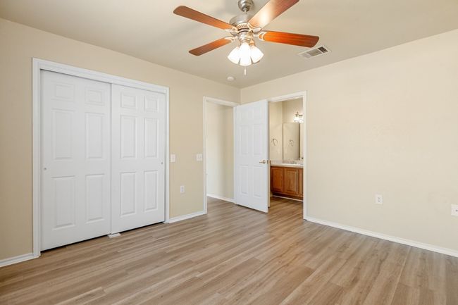 Unfurnished bedroom featuring light wood-type flooring, a closet, ceiling fan, and ensuite bathroom | Image 18