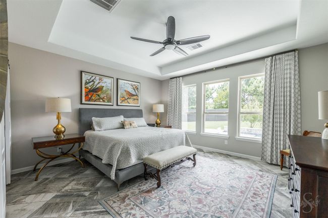 The primary bedroom is spacious, easily accommodating a king-size bed, and is designed for handicap accessibility throughout. It features a new fan and drapes that add both comfort and sophistication to the space. | Image 20