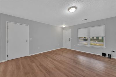 Unfurnished room featuring hardwood / wood-style floors and a textured ceiling | Image 2