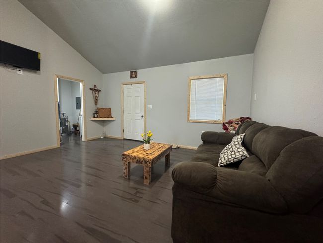 Living room with vaulted ceiling and dark wood-type flooring | Image 7