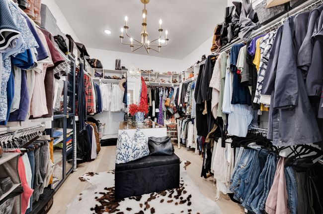 Walk in closet featuring a chandelier and wood finished floors | Image 24